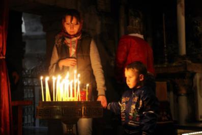 A mother and son light candles in the Church of the Holy Sepulcher in the Old City of Jerusalem. This album documents my journeys in Israel and the West Bank.